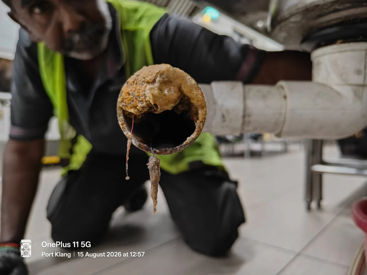 Hardened grease blocking an under-sink drain line at a steel processing plant in Klang