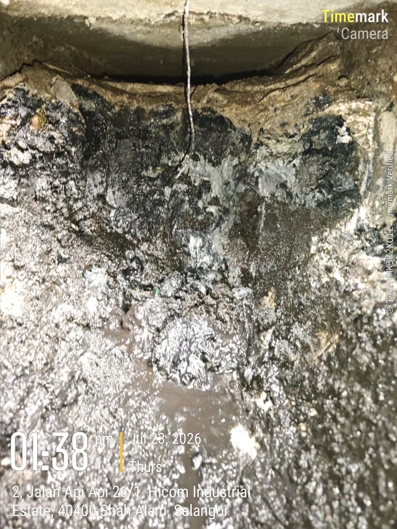 Hardened obstruction inside a factory rainwater drain at Hicom Industrial Estate